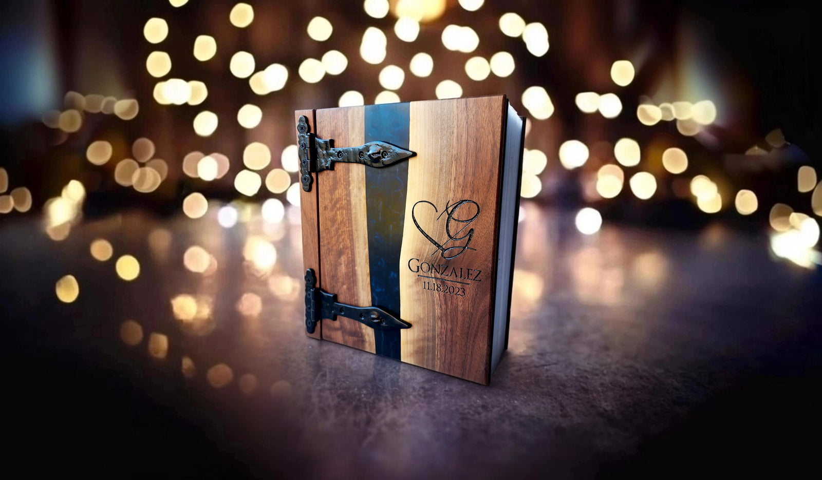 Elegant wooden photo album with hinges and Gonzalez logo, set against a blurred backdrop of warm lights.